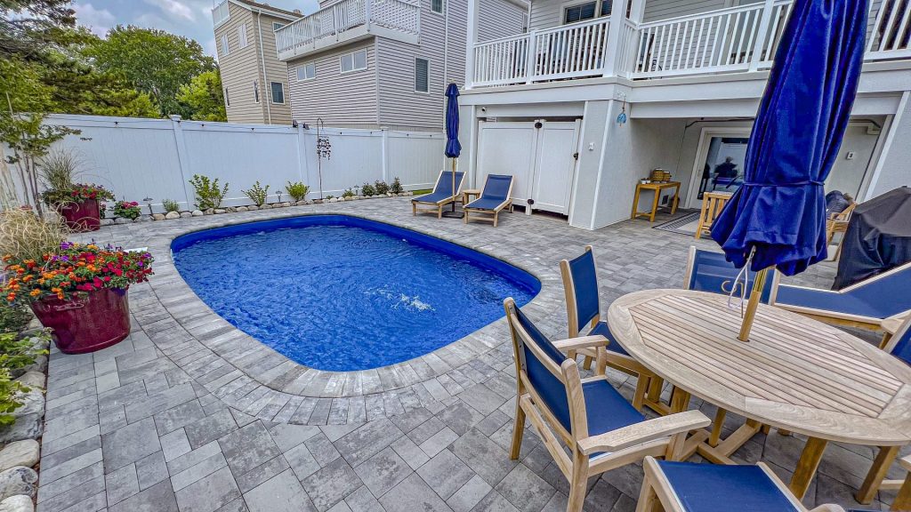 Sundial Fiberglass pool shell from glimmerglass completed backyard - MGK Pools Inc Sundial Inground Fiberglass Pool with patio completed in back yard